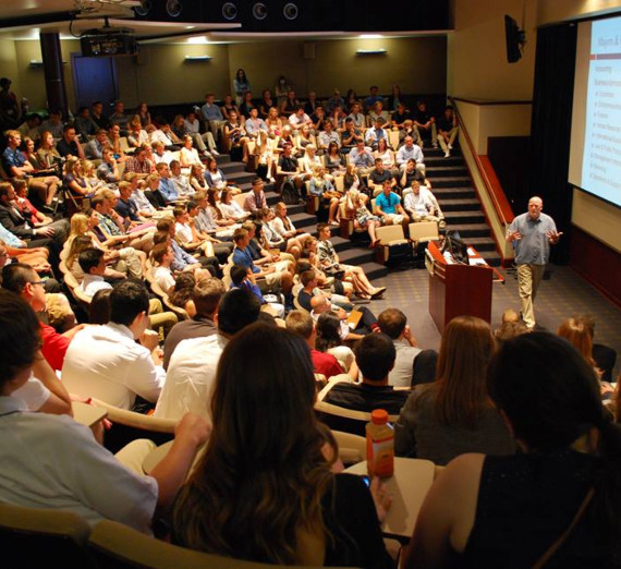 卒業帽とローブを着た女性が学位証を掲げて笑顔